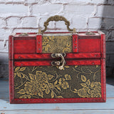Decorative jewelry box with floral patterns on a wooden surface and brick wall background