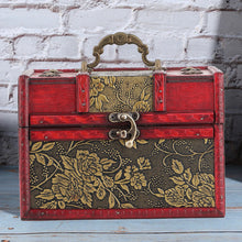 Decorative jewelry box with floral patterns on a wooden surface and brick wall background
