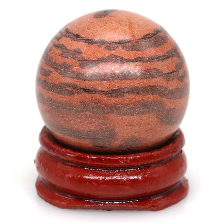 Red and brown striped sphere on a matching wooden stand against a white background