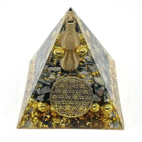 Pyramid-shaped object with gold and black elements on a white background