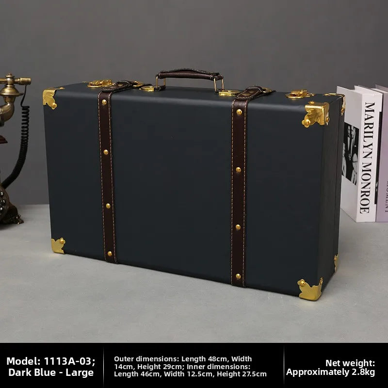 Dark blue suitcase with brown straps on a gray surface