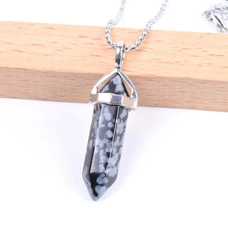 Crystal pendant necklace on a white background with a wooden stick