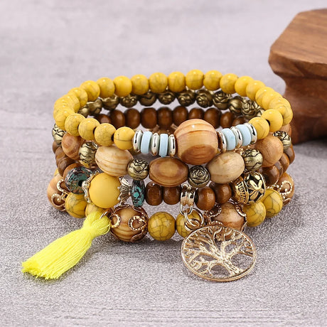 Stack of colorful beaded bracelets with a yellow tassel on a gray surface