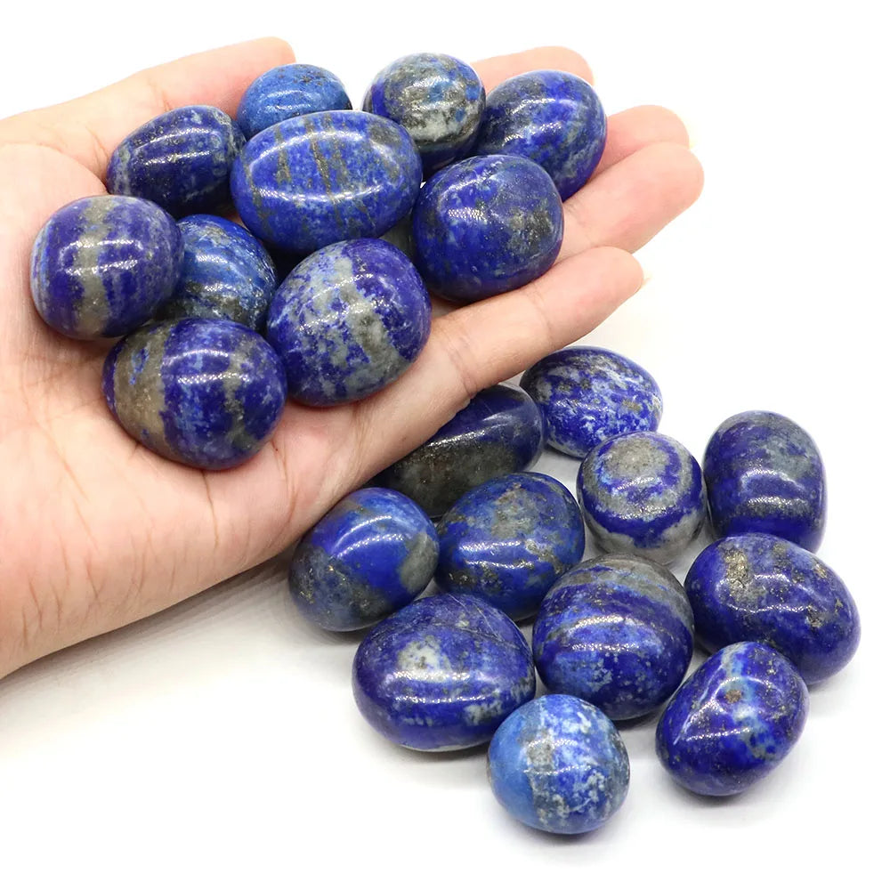 Hand holding blue and gray marbled stones on a white background