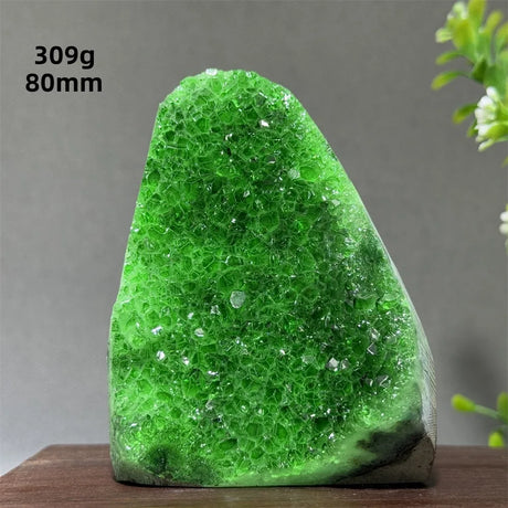 Green crystal rock on a wooden surface with measurements displayed