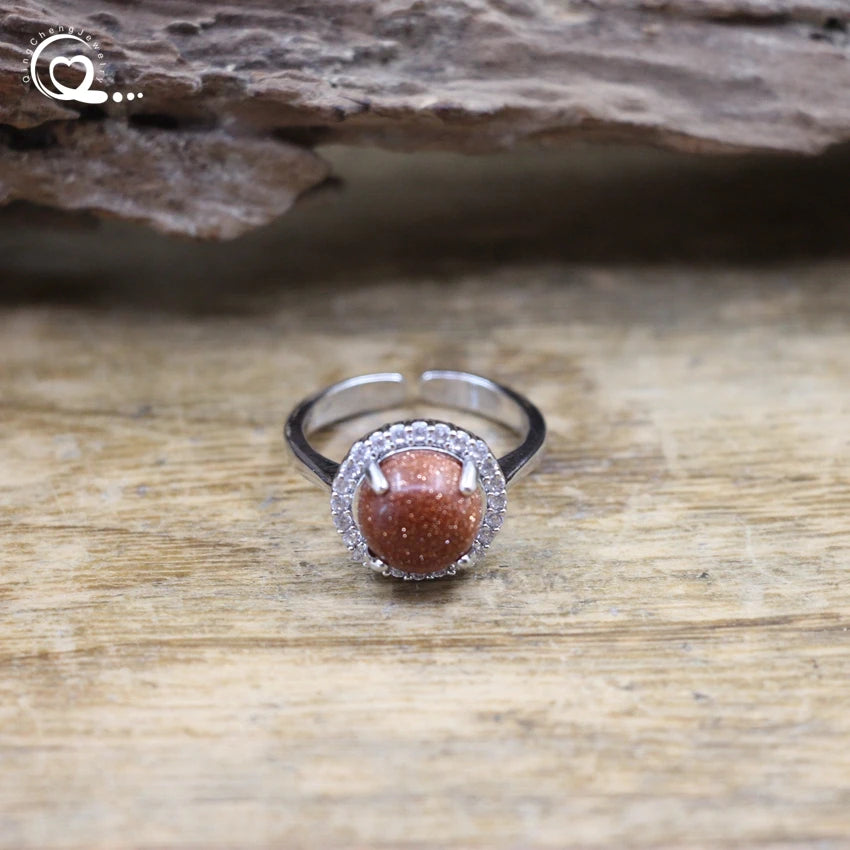 Silver ring with a brown gemstone on a wooden surface