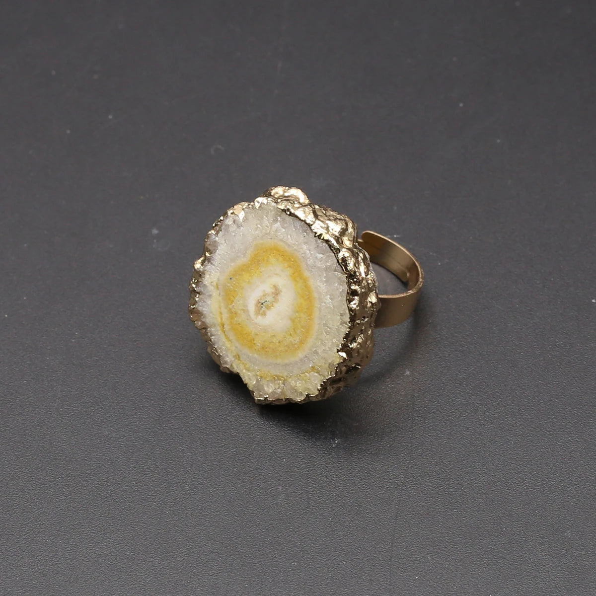 Gold and stone ring on a dark gray background