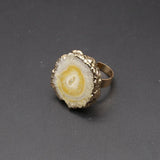 Gold and stone ring on a dark gray background