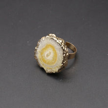 Gold and stone ring on a dark gray background