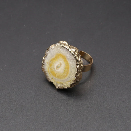 Gold and stone ring on a dark gray background