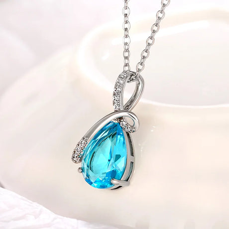 Teardrop-shaped blue gemstone necklace on a white background