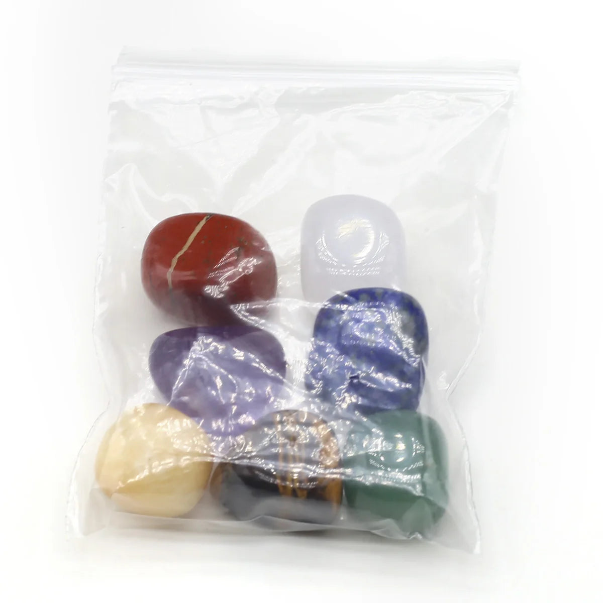 Set of colorful stones in a clear plastic bag on a white background