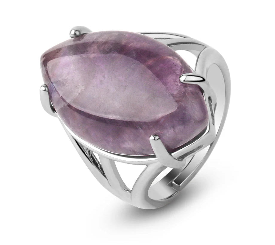 Silver ring with a large purple gemstone on a white background