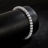 Diamond bracelet on a black cylindrical stand with a dark background