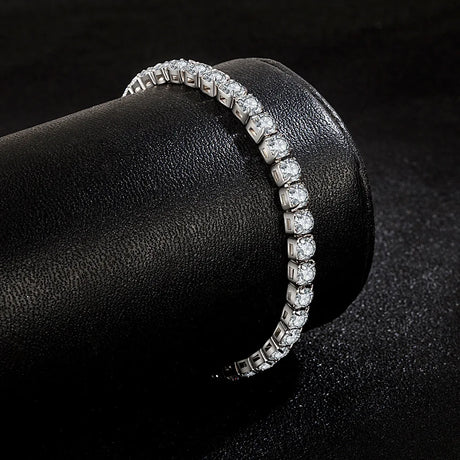 Diamond bracelet on a black cylindrical stand with a dark background