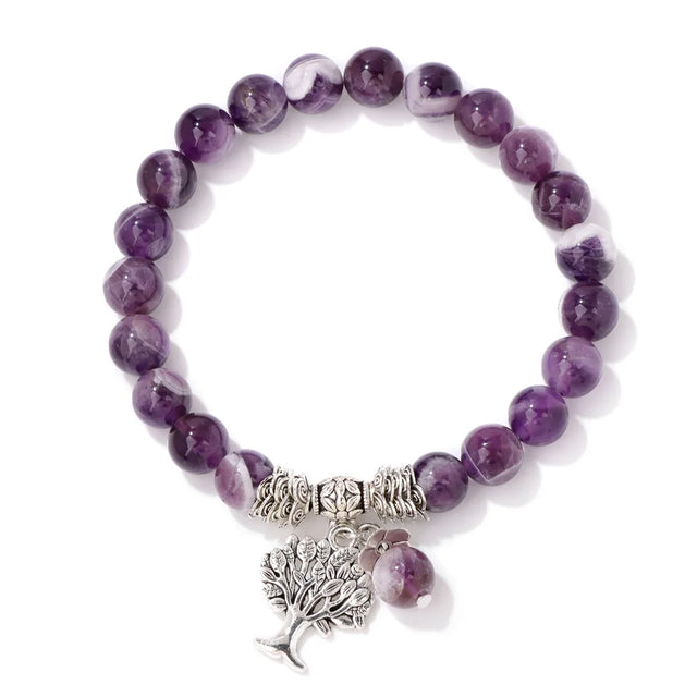 Purple beaded bracelet with a silver tree charm on a white background
