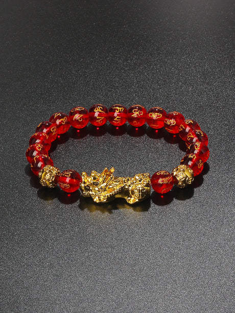 Red beaded bracelet with gold accents on a dark gray background
