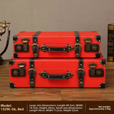 Two red vintage-style suitcases stacked on a wooden surface with product details.