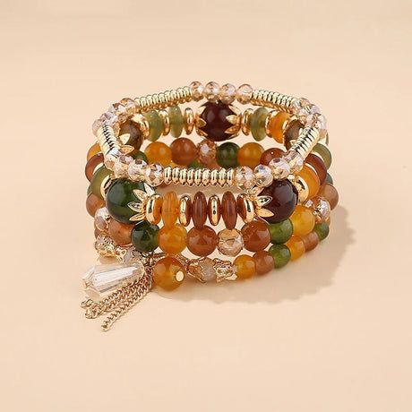 Set of beaded bracelets with gold accents on a beige background