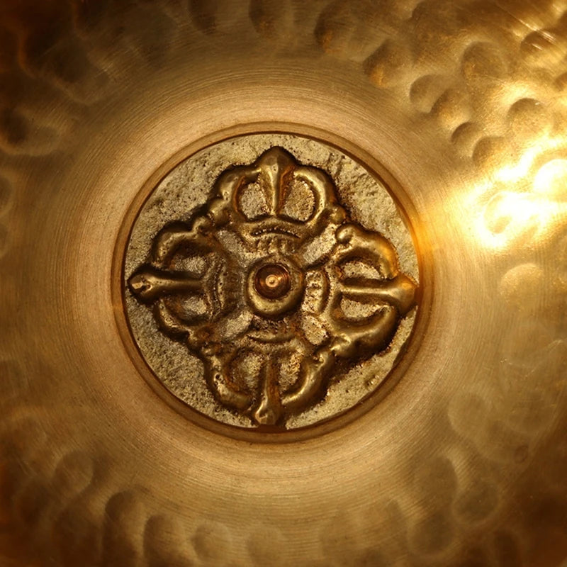 Close-up of a gold decorative emblem on a textured gold surface.