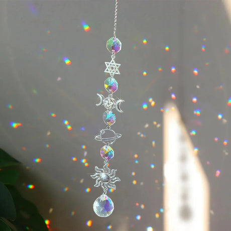 Decorative hanging crystal with celestial designs on a blurred background