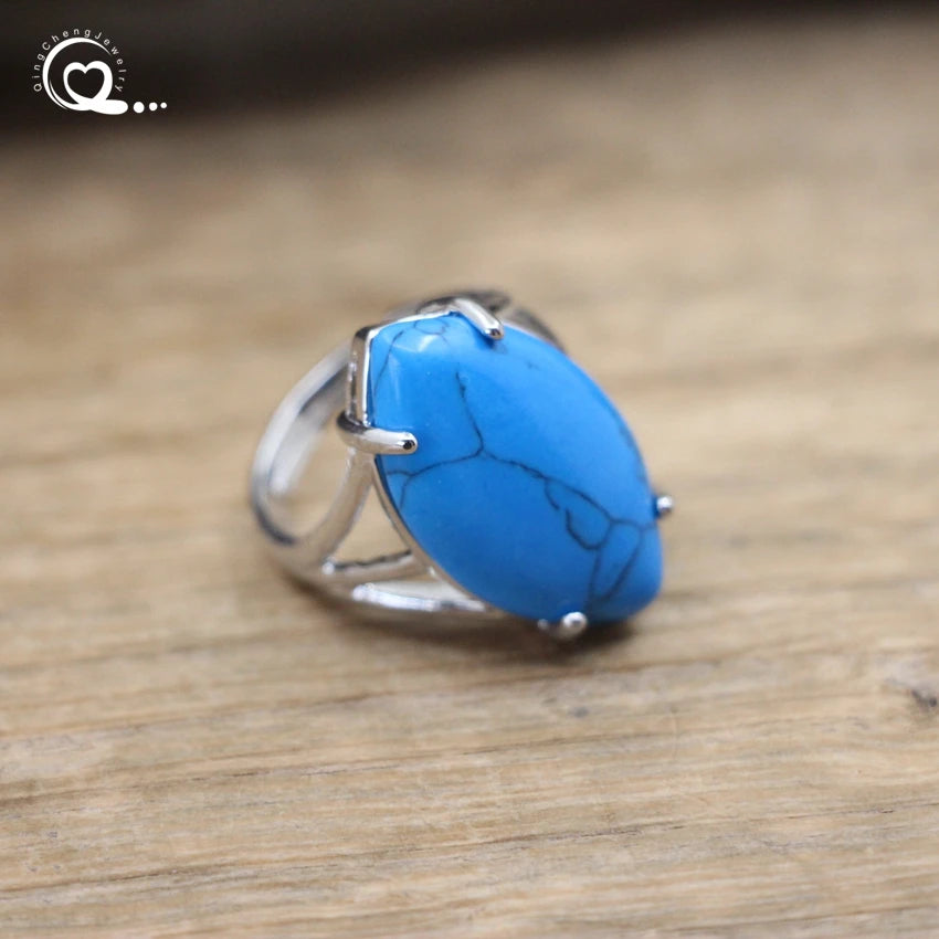 Silver ring with a blue stone on a wooden surface