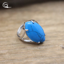 Silver ring with a blue stone on a wooden surface