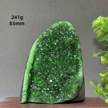 Green crystal rock on a wooden surface with a gray background