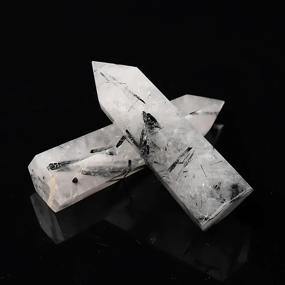 Two crystal formations on a black reflective surface