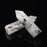 Two crystal formations on a black reflective surface