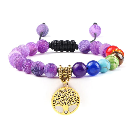 Multicolored beaded bracelet with a gold tree of life charm on a white background