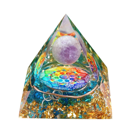 Crystal pyramid with colorful base and purple sphere on a white background