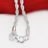 Silver rope chain necklace with clasp on a red and white background