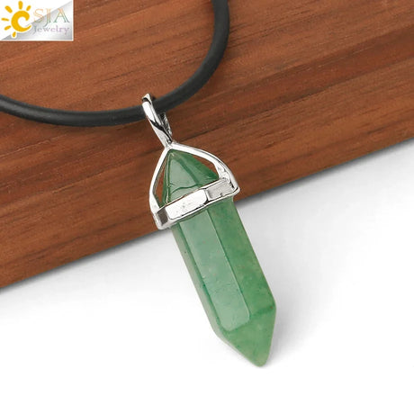 Green crystal pendant on a black cord with a wooden background