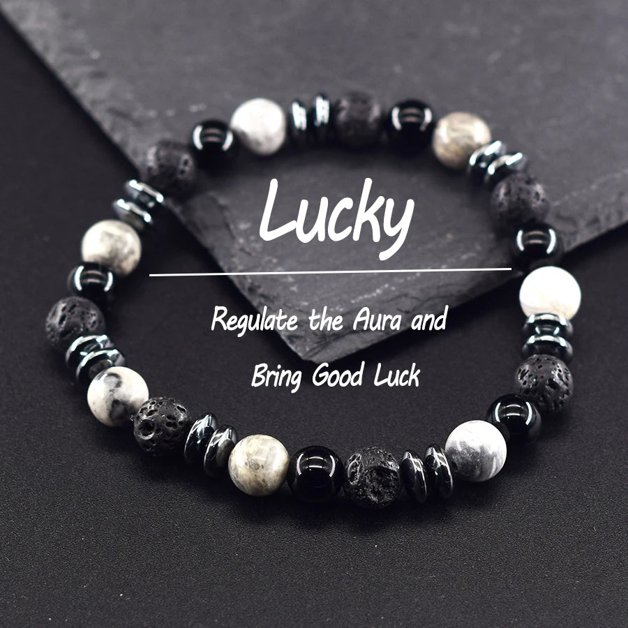 Black and white beaded bracelet on a dark surface with text about regulating the aura and bringing good luck.