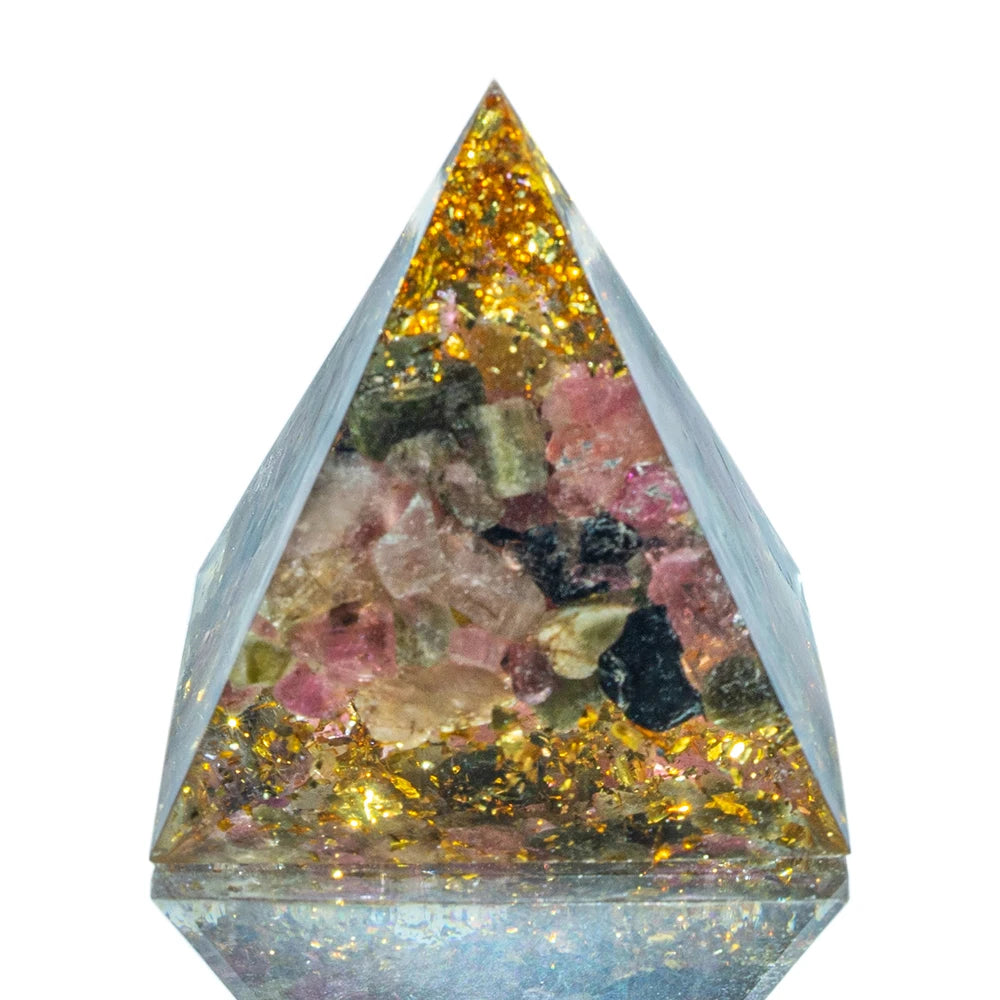 Pyramid-shaped crystal with embedded colorful stones on a white background