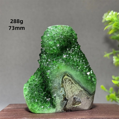 Green crystal rock on a wooden surface with a gray background