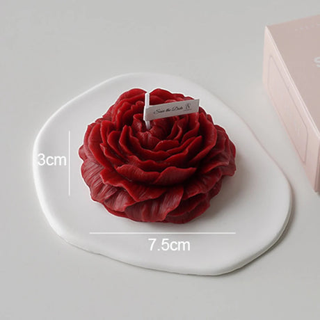 Red rose-shaped object on a white heart-shaped base with measurements and a card.