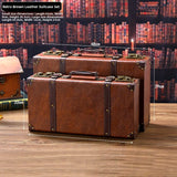 Retro brown leather suitcase set on a wooden surface with dimensions displayed.