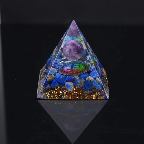 Pyramid-shaped crystal with embedded stones on a black background