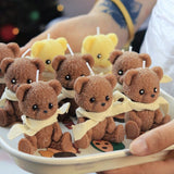 Small brown teddy bears with yellow scarves on a white plate.