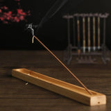 Incense stick burning on a wooden holder with a blurred background