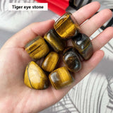 Hand holding tiger eye stones with a blurred background