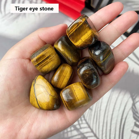 Hand holding tiger eye stones with a blurred background