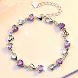 Silver bracelet with purple heart-shaped stones on a beige background