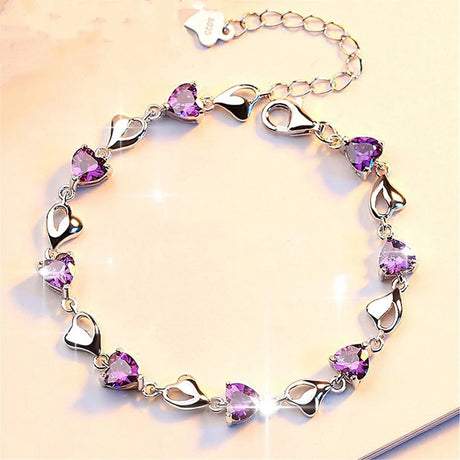 Silver bracelet with purple heart-shaped stones on a beige background