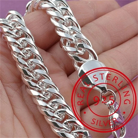 Silver chain bracelet held in hand with 'Real Sterling Silver 925' stamp.