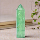 Green crystal tower on a textured surface with a blurred background