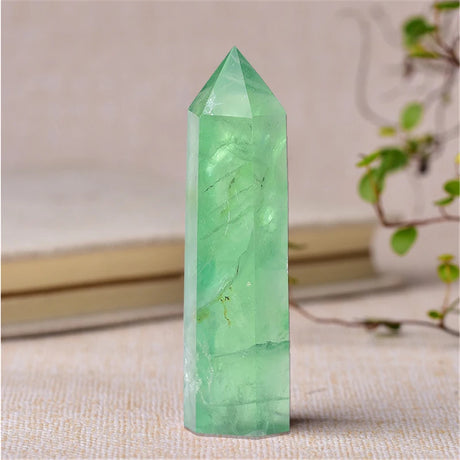 Green crystal tower on a textured surface with a blurred background