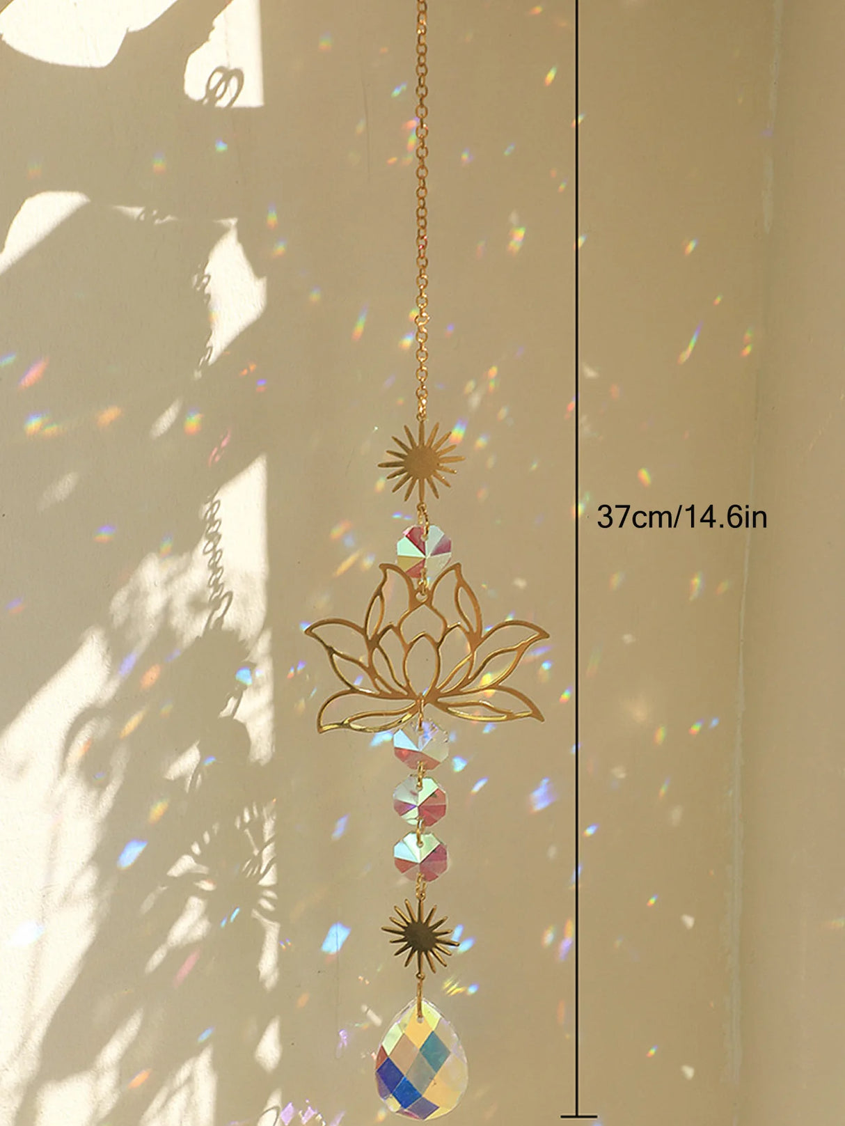 Decorative hanging crystal sun catcher with gold lotus design and colorful gemstones, against a neutral background.